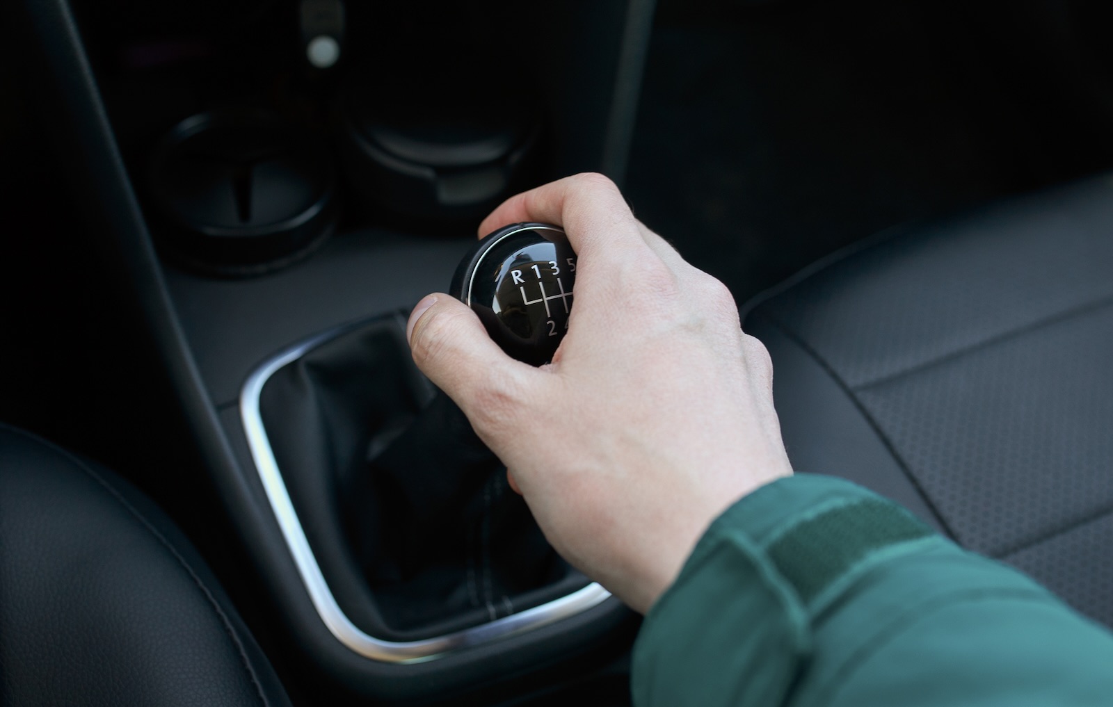Hand on the shift lever of a manual transmission car