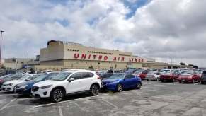 Cars parked outside a terminal at an airport.