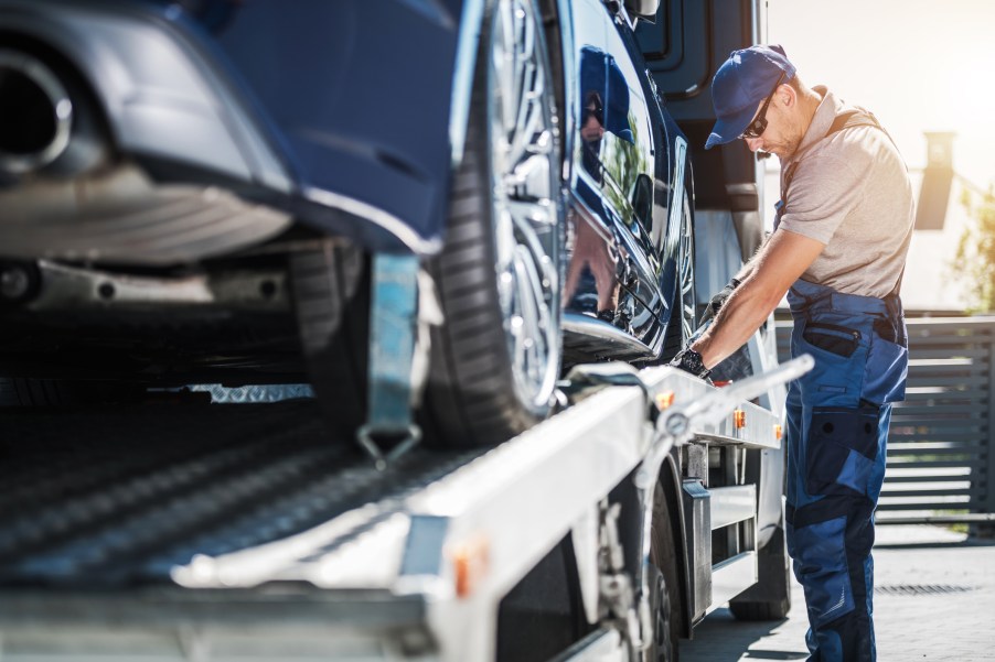 A tow truck operator loading a car