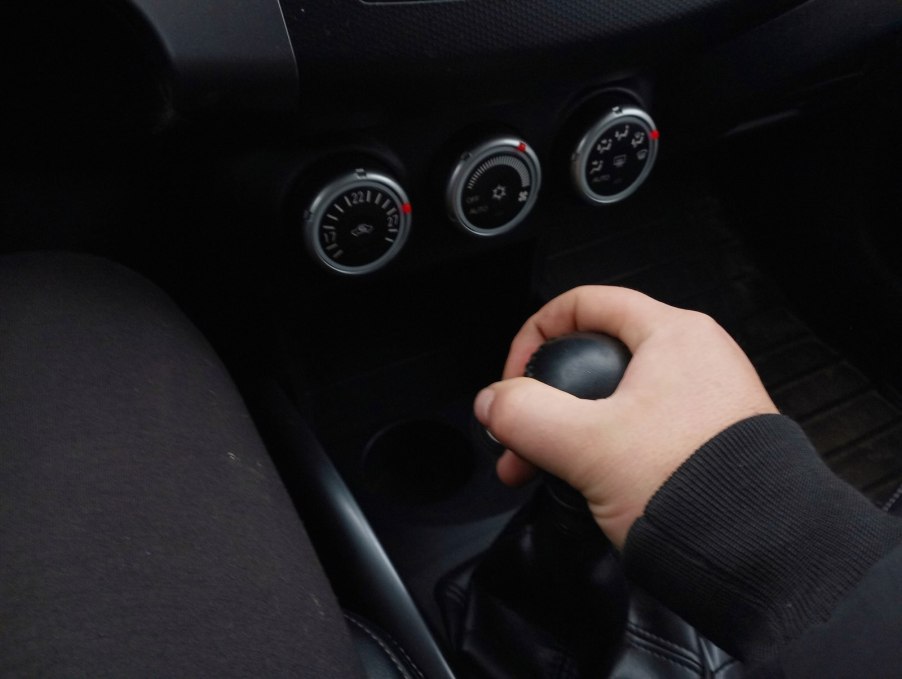 Hand holding a gearshift lever in a manual transmission. Toyota HILux