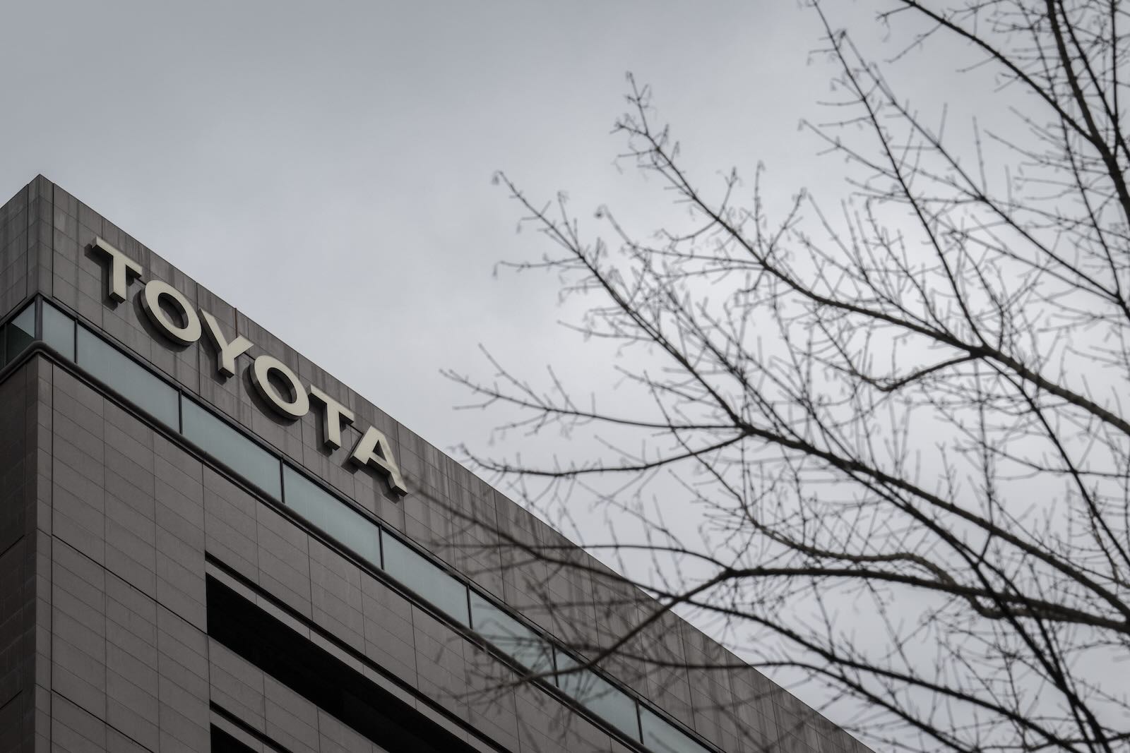 Toyota sign on headquarters building, gray sky in the background.