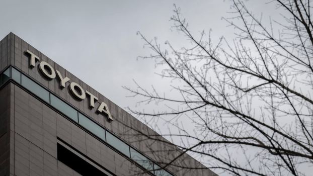 Toyota sign on headquarters building, gray sky in the background.