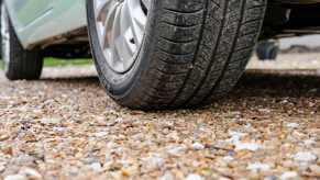 A car parked on gravel in very close low left rear angle view