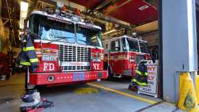 FDNY trucks parked inside fire station view from open doors