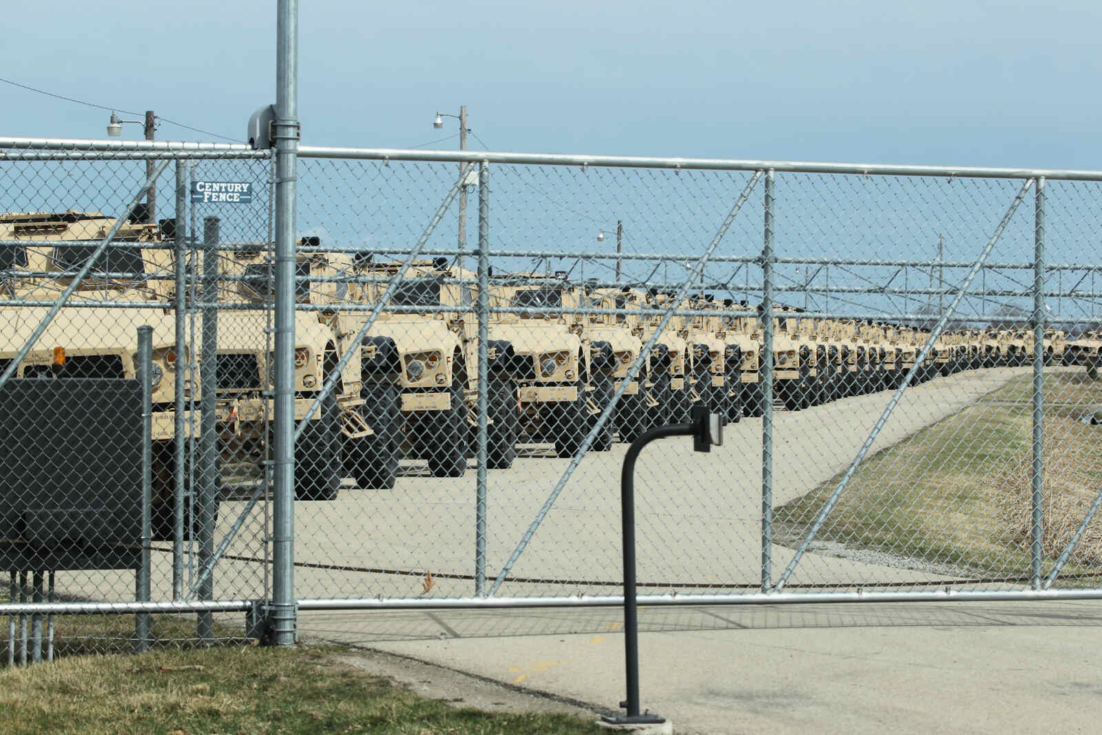 Oshkosh Defense JLTV models lined up inside a chain link fence