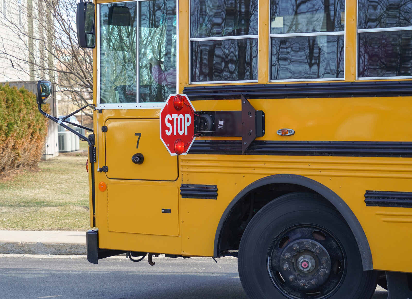 A stopped school bus in close left front profile view