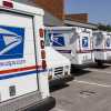 USPS mail trucks parked outside a distribution center