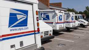 USPS mail trucks parked outside a distribution center