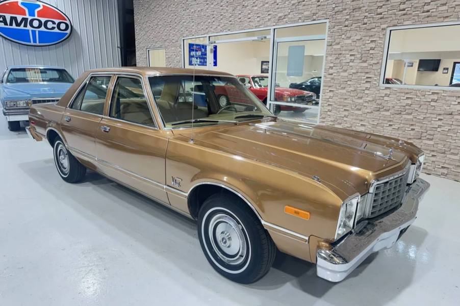 A gold 1979 Plymouth Volare Custom Sedan in a showroom in right front angle view