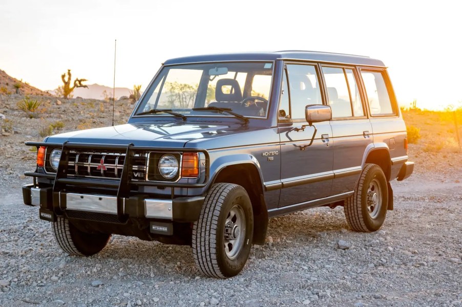 A blue 1990 Mitsubishi Montero 5-Speed parked in the desert in left front angle view