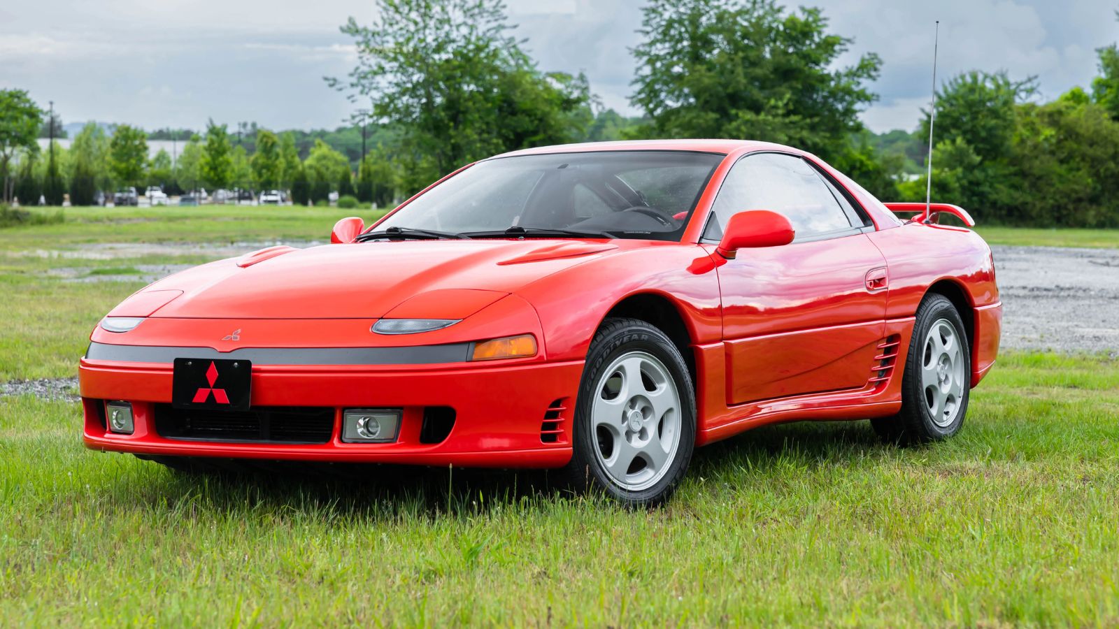 A red 1992 Mitsubishi 3000GT SL parked on grass in left front angle view