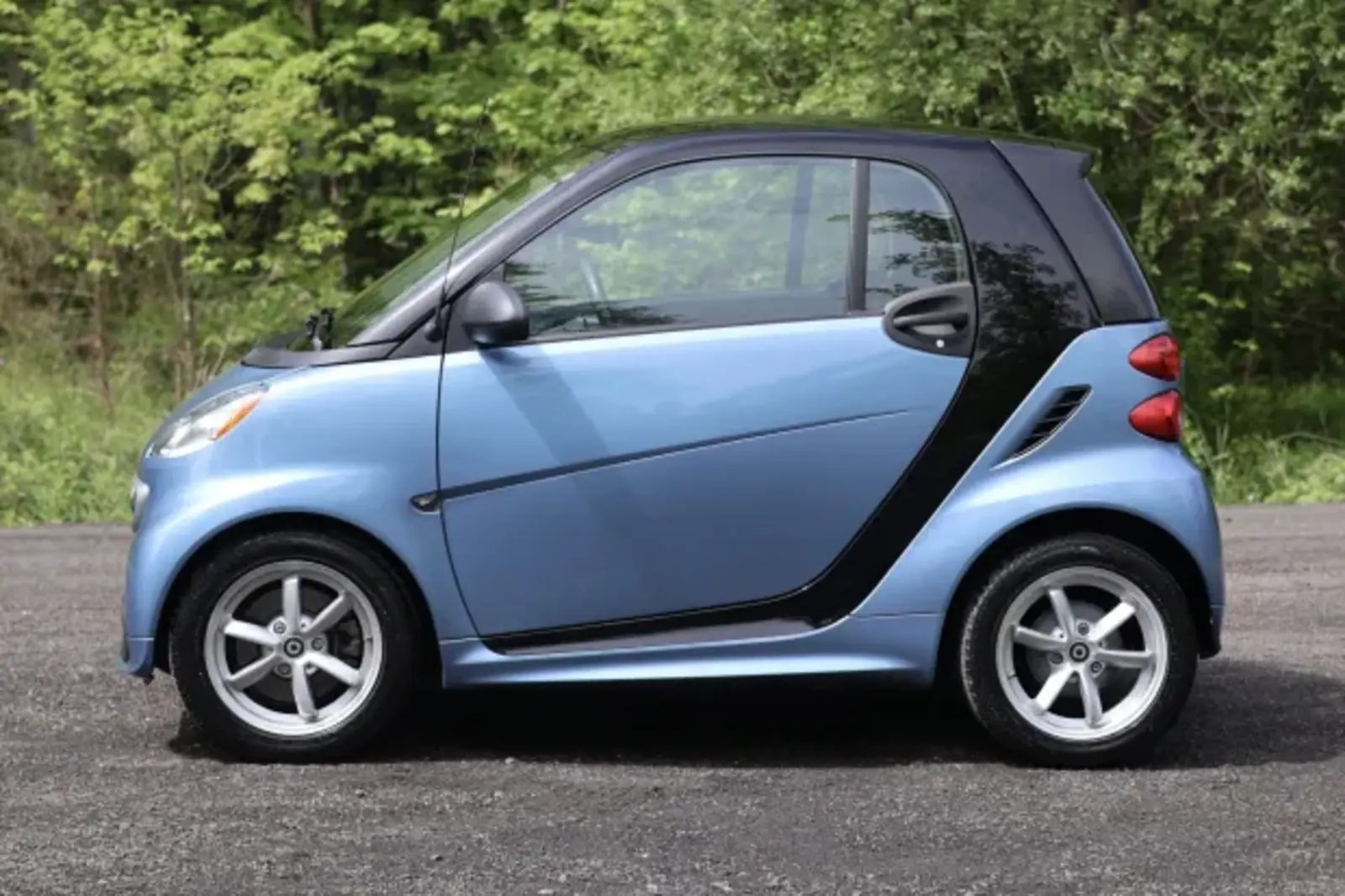 A blue 2014 Smart Fortwo parked in left profile view