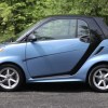 A blue 2014 Smart Fortwo parked in left profile view