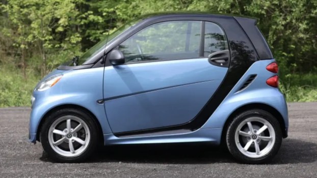 A blue 2014 Smart Fortwo parked in left profile view