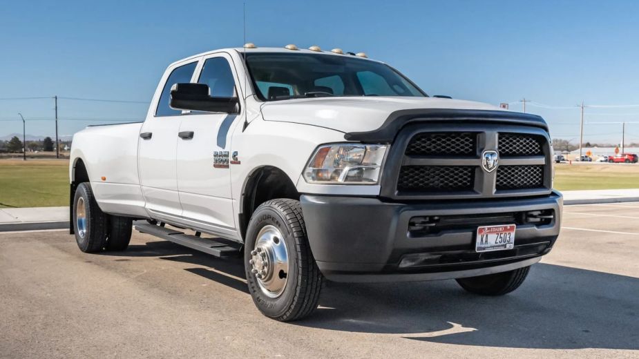 A white 2015 Dodge Ram 3500 ST Crew Cab Dually Cummins 4×4 parked in low right front angle view