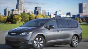 A grey 2018 Chrysler Pacifica Hybrid parked in left front angle view in front of a city skyline