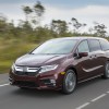 A maroon 2018 Honda Odyssey driving in left front angle view