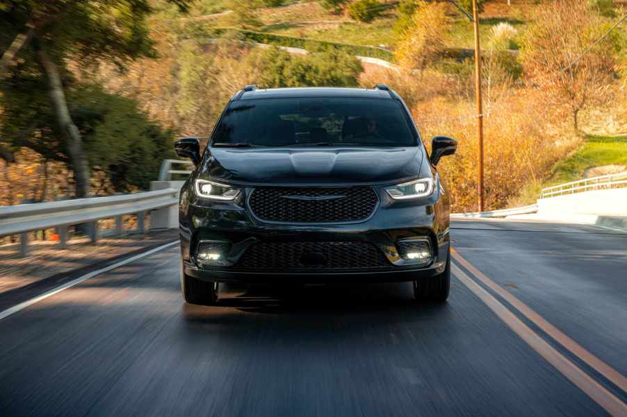 A black 2022 Chrysler Pacifica driving on a highway in direct front view