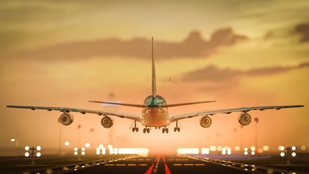 Airplane flying just above runway at airport, moments before landing