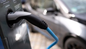 BMW i3 behind a BMW-branded EV charger cable.