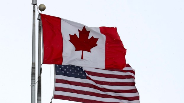 The Canadian and U.S. flag fly side-by-side.