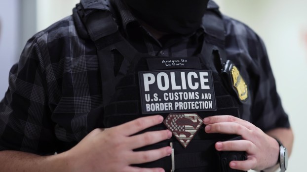 U.S. Customs and Border Protection ICE officer holding onto his vest.
