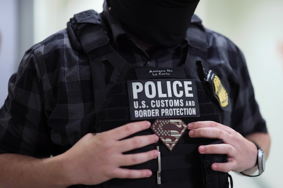 U.S. Customs and Border Protection ICE officer holding onto his vest.