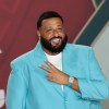 DJ Khaled on stage in a turquoise blazer.