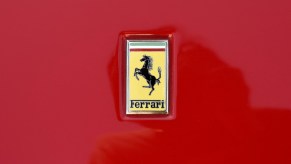Yellow Ferrari logo on the hood of a red sports car.