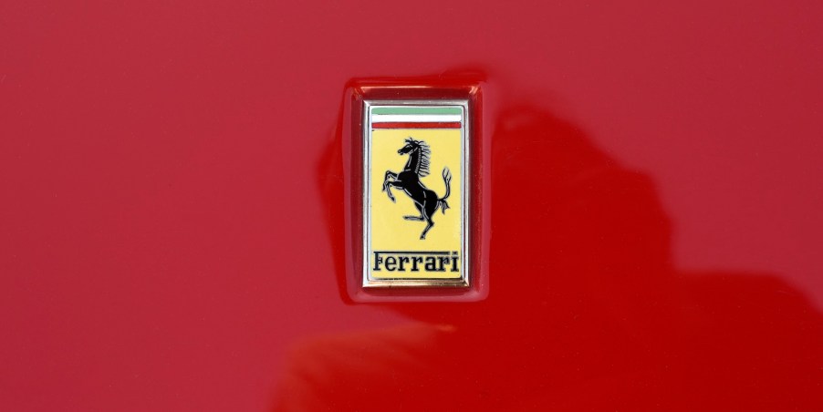 Yellow Ferrari logo on the hood of a red sports car.