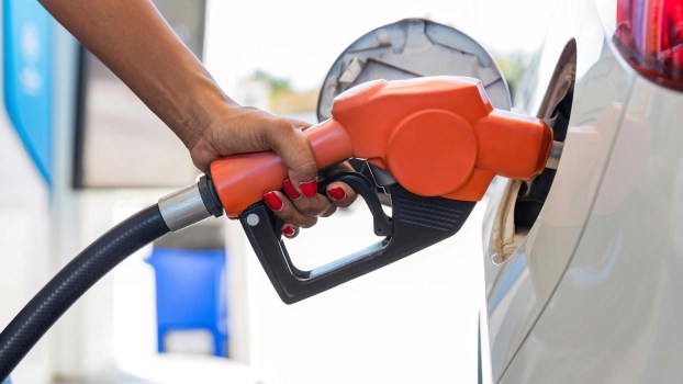 A woman putting gas in her car