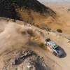 Overhead view of Toyota's Yaris rally car skidding through a mountain switchback during a race in Saudi Arabia.