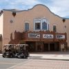 Two golf carts parked outside a movie theater on Main Street in a Florida town