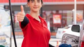 Happy driver fills efficient car at gas station.