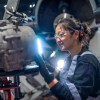 Mercedes-Benz dealer technician works on a car in a shop.