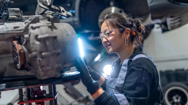 Mercedes-Benz dealer technician works on a car in a shop.