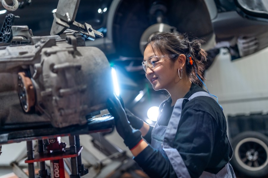 Mercedes-Benz dealer technician works on a car in a shop.