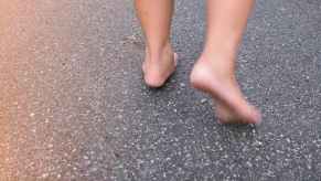 The feet of a Florida man running on the pavement of a road.