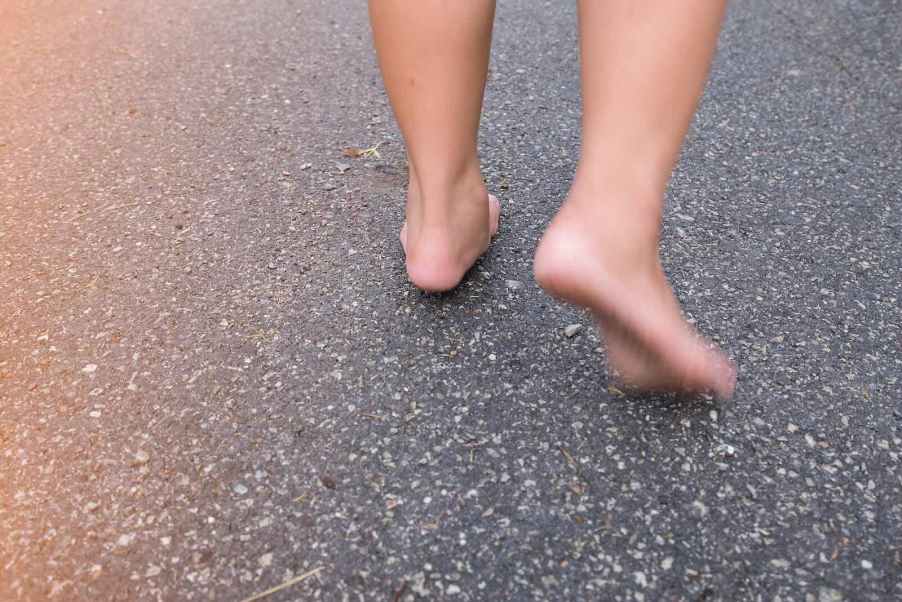 The feet of a Florida man running on the pavement of a road.