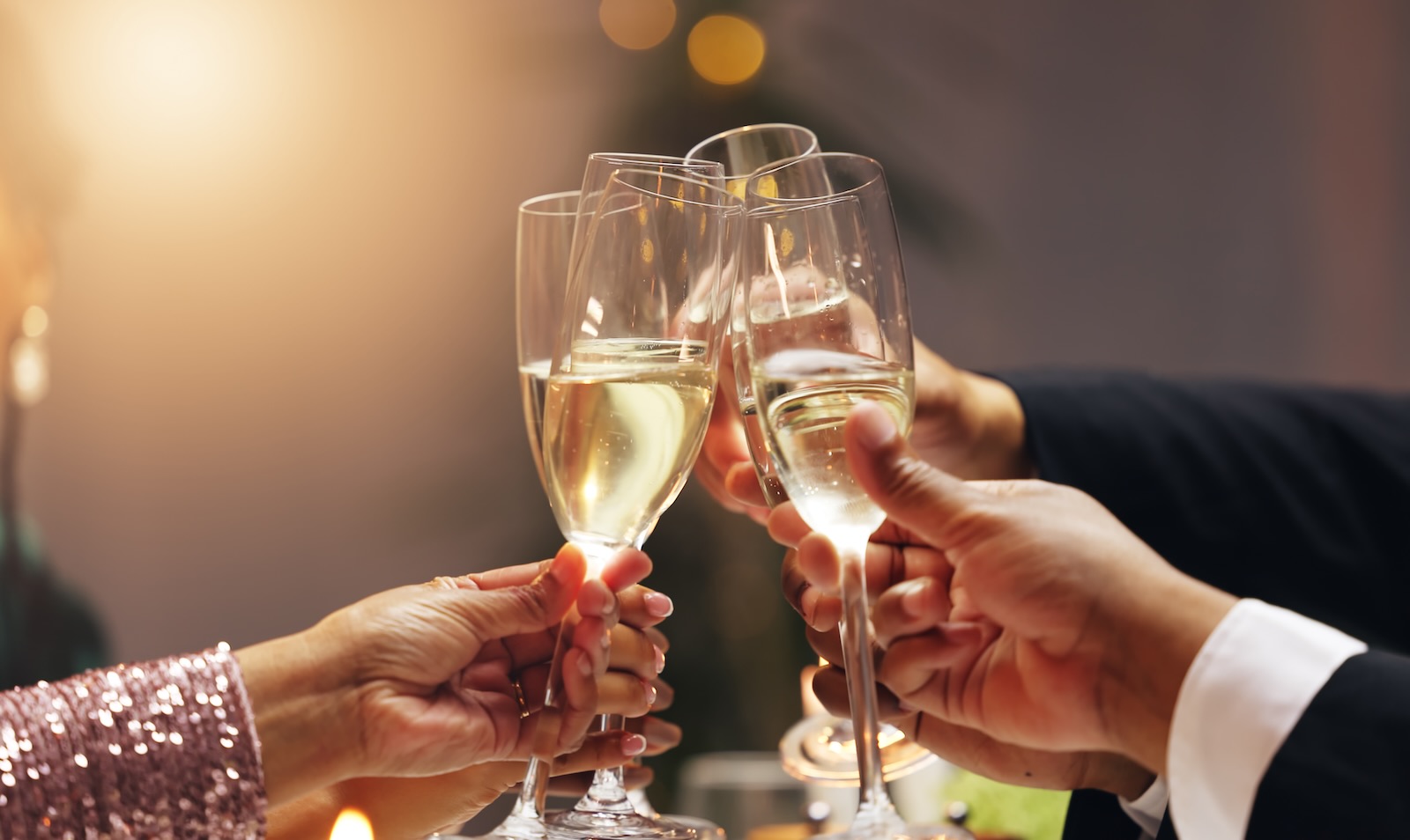 Hands holding champagne during a New Year's toast.