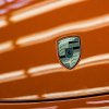 The Porsche Logo on a bright orang hood