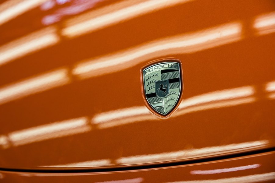 The Porsche Logo on a bright orang hood