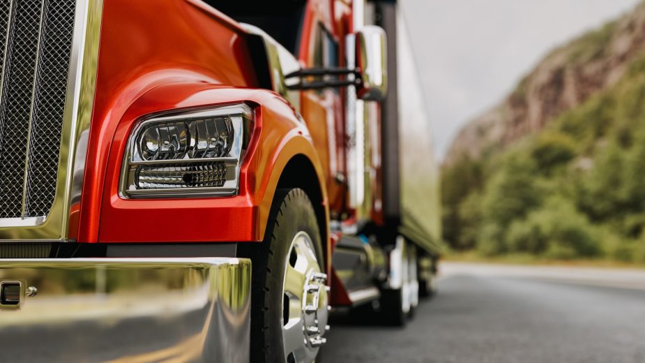 Closeup of the bumper and front tires of an 18-wheeler semi truck.