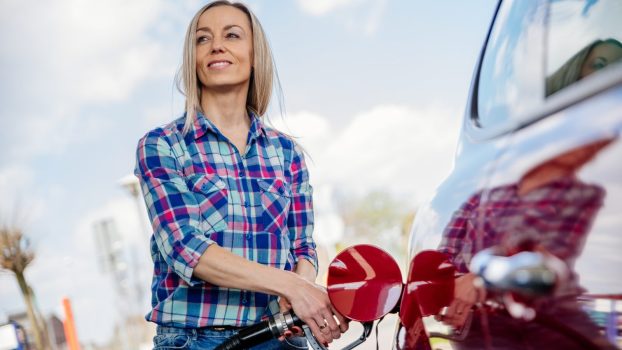Driver fueling up smiles at low gas prices.