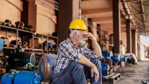 Older factory worker sitting on a pallet in Ontario Brampton.