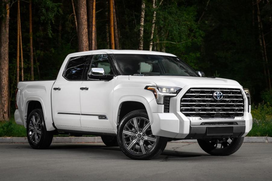 White Toyota Tundra pickup truck parked in front of a forest.