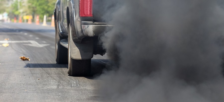 A truck rolling coal on the road