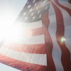 U.S.A. national flag waving with the sun visible in the background.
