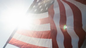 U.S.A. national flag waving with the sun visible in the background.