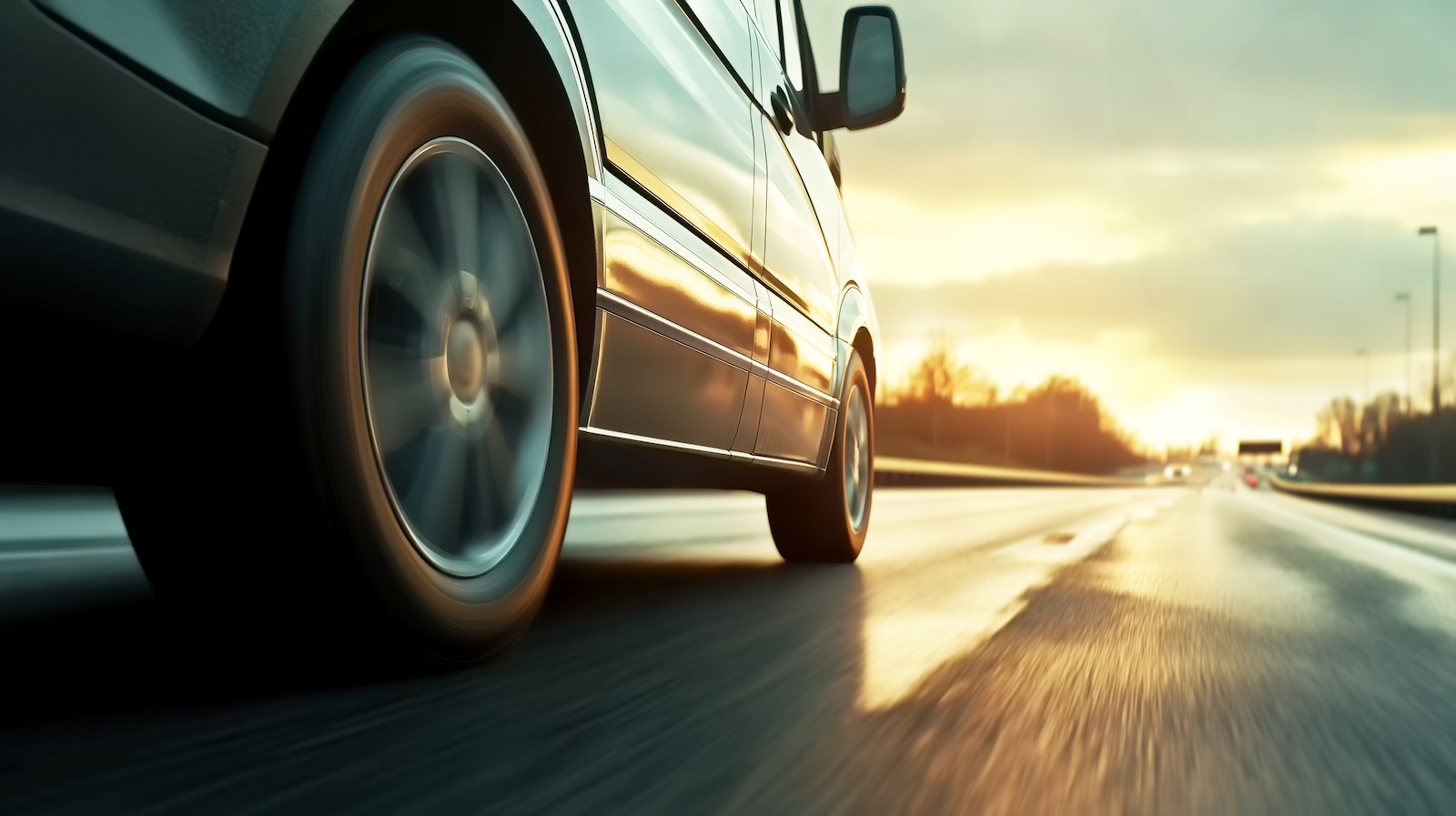 Van driving into the sunset along an empty highway on high mpg tires.